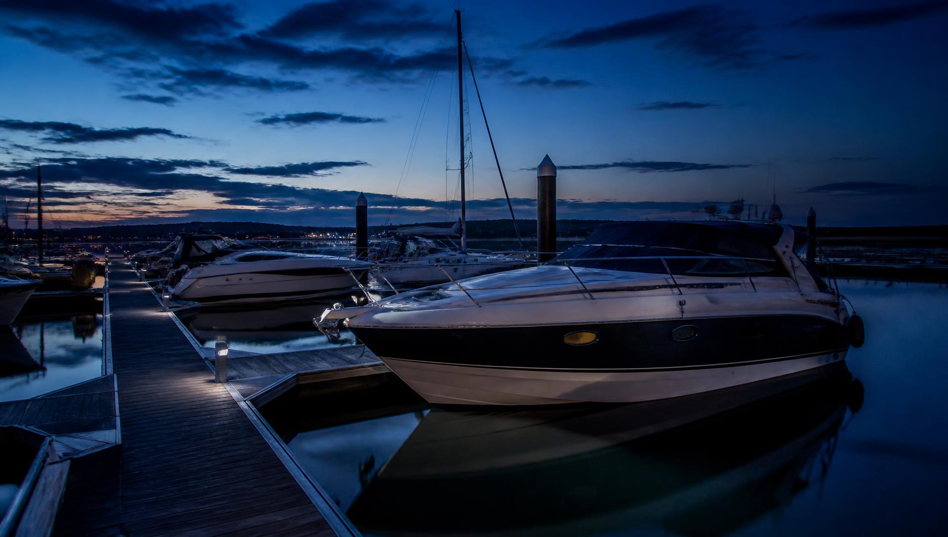 Motorboats and yachts moored in a UK marina at dusk